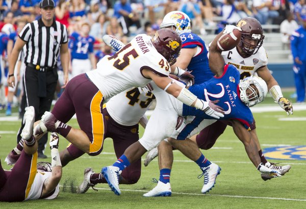 Kansas junior running back De'Andre Mann (23) fights for extra yardage against the Central Michigan defense during their game on Saturday afternoon at Memorial Stadium.