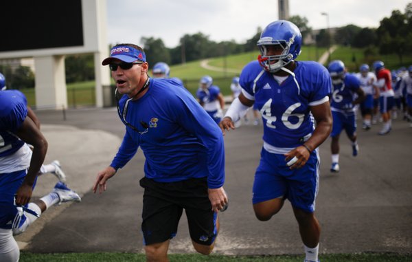 Kansas interim head football coach Clint Bowen runs out to the practice with the team on Wednesday, Oct. 1, 2014.