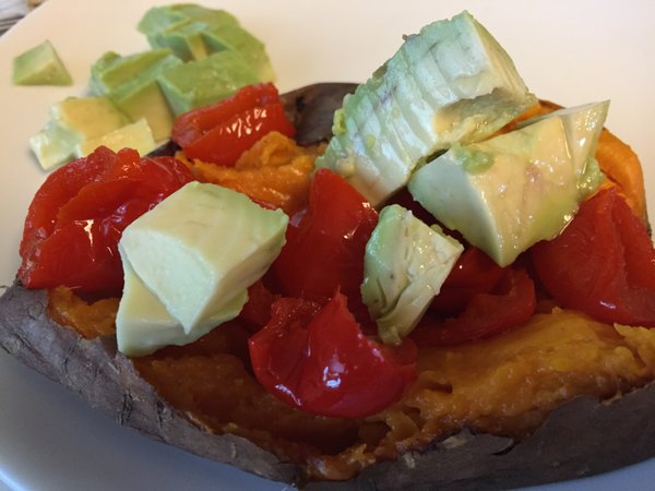 A "baked" sweet potato made in the slow cooker and topped with peppadew peppers and avocado.