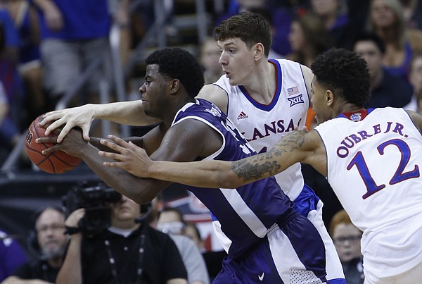 Kansas center Hunter Mickelson (42) and Kelly Oubre (12) put pressure on TCU's Chris Washburn (34) in the Jayhawks 64-59 win over TCU Thursday.