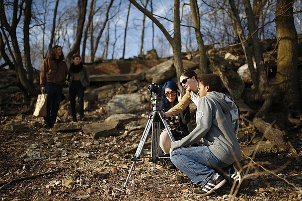 Marlo Angell, Lawrence Arts Center digital media director, helps Van Go student directors Darius Vann and  Annastasia Payne, back right, compose a shot as they shoot portions of a short film on March 12, 2015, along the south bank of the Kansas River. Their film was among those made by Van Go and Boys and Girls Club students shown at the Outreach Film Showcase event last summer at the Lawrence Arts Center as part of the Free State Festival.