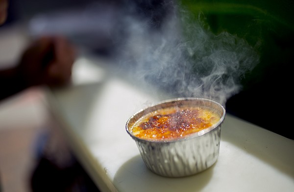 Smoke rises off a freshly torched creme brulee from the Torched Goodness food cart at Seventh and Massachusetts streets on Friday afternoon.