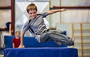 Eleven-year-old Christian Bandel uses one arm to spring over a vault during a parkour class held at Lawrence Gymnastics Academy, 4930 Legends Dr. on Sunday, May 17, 2015.