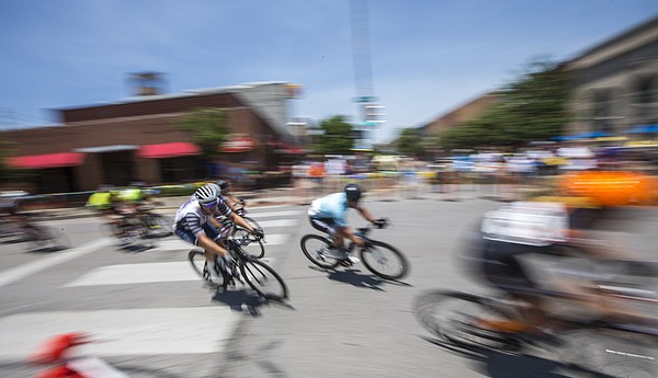Cyclists competing in the men's pro race speed around a corner during the Tour of Lawrence downtown criterium Sunday, June 28, 2015.