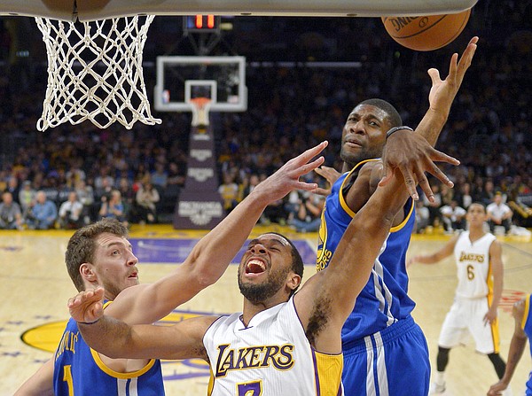 Los Angeles Lakers forward Xavier Henry, center, puts up a shot as Golden State Warriors center Ognjen Kuzmic, left, of Bosnia, and center Festus Ezeli, of Nigeria, defend during the second half of an NBA basketball game, Sunday, Nov. 16, 2014, in Los Angeles. The Warriors won 136-115. (AP Photo/Mark J. Terrill)
