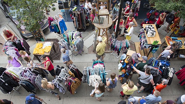 Shoppers check out the deals at Sunflower Outdoor and Bike Shop, 804 Massachusetts St., during the Downtown Lawrence Sidewalk Sale, Thursday, July 16, 2015.