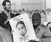 Ron Washington, chairman of the Black Students Union at Kansas University, left, addresses a strike rally on campus in this file photo from December 1970, as an unidentified youth displays a sign in memory of Rick "Tiger" Dowdell. Dowdell was fatally shot while fleeing police on July 16, 1970.