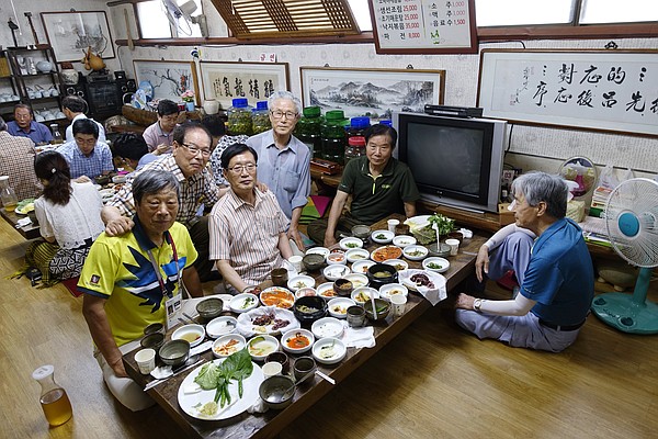 After a meal shared with a group of South Korean men, I wanted to capture the memory in a photograph. As I framed my photograph I witnessed solemn expressions instead of the smiling ones I had experienced during our meal.