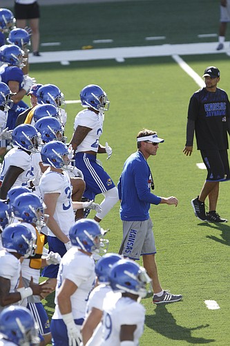 Kansas assistant head coach and defensive coordinator Clint Bowen leads players in drills at a KU football practice, part of fan appreciation activities Saturday August 8, 2015.