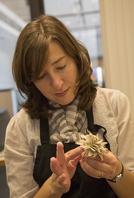 Christy Wittmer, the 2015-2016 ceramics artist-in-residence at the Lawrence Arts Center, works on a clay flower in her new studio. 