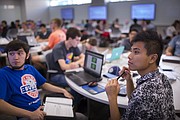 Kansas University sophomores from Wichita, Timothy Spencer Kaba, left, and Tyler Van turn to read notes projected onto one of over a dozen large flatscreen monitors hanging on the wall of an engineering lecture room in the new engineering building, Wednesday, Aug. 26, 2015. The class, Material and Energy Balances, taught by chemical and petroleum engineering professor, Susan Williams, is an example of a "flipped class," which requires that students review the lecture content before class in an effort to facilitate a more interactive group discussion during class meetings.