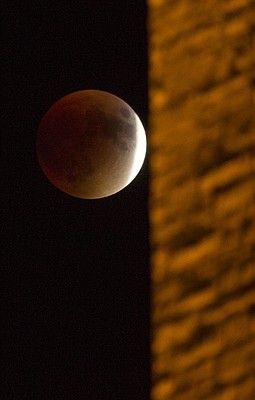 A blood moon moves behind the illuminated stones of the Campanile on the Kansas University campus Sunday night, Sept. 27, 2015.
