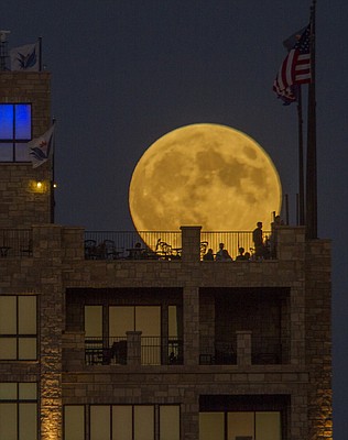 People gather at The Nest on Ninth at The Oread to watch a harvest moon, a full moon nearest the September equinox, come up Sunday night, Sept. 27, 2015. Later there was an eclipse of the moon which has led many to call this event a rare super blood moon. This combination of events won't happen again until 2033. 