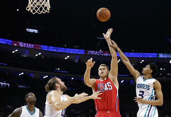 Cole Aldrich of Los Angeles Clippers, second right, shoots over Jeremy Lamb, right, Spencer Hawes, second left, and Marvin Williams, left, of Charlotte Hornets during the NBA Global Games at the Mercedes-Benz Arena in Shanghai, China, Wednesday, Oct. 14, 2015. (AP Photo/Andy Wong)