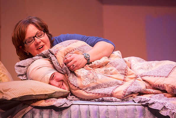 Stephen, played by Christoph Cording, hides under sheets and blankets as Carol, played by Hailey Gillespie, mistakes him for her boyfriend during a dress rehearsal for Theatre Lawrence's upcoming production of "Girls' Weekend" on Thursday, Jan. 14, 2016. The show opens on Jan. 22 with a curtain time of 7:30 p.m. at Theatre Lawrence, 4660 Bauer Farm Dr.