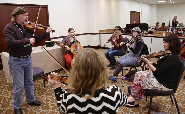 Lawrence resident Megan Hurt, second from right, attends a Celtic fiddle and cello workshop Thursday, Feb 18, from Alasdair Fraser, left, and Natalie Haas, seated left, at the Folk Alliance International Conference in K.C., MO that goes through Sunday.