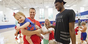 Enårige Landley Sheppard er lidt for genert til at møde Andrew Wiggins, da hun bliver båret over af sin far Mark Sheppard under Wiggins' og Ben McLemores Kansas All-Star Basketball Camp torsdag den 14. juli 2016 på Sports Pavilion Lawrence. I midten er Heather Sheppard.