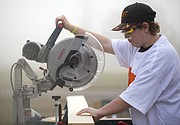 Tristan Crocker, Lawrence, uses a saw to cut support boards as he and his fellow students work to build a cabin on Thursday, Oct. 27, 2016 at Peaslee Tech, 2920 Haskell Ave.
