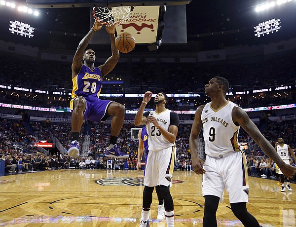 Los Angeles Lakers center Tarik Black (28) slam dunks over New Orleans Pelicans forward Anthony Davis (23) and forward Terrence Jones (9) in the second half of an NBA basketball game in New Orleans, Saturday, Nov. 12, 2016. The Lakers won 126-99. (AP Photo/Gerald Herbert)