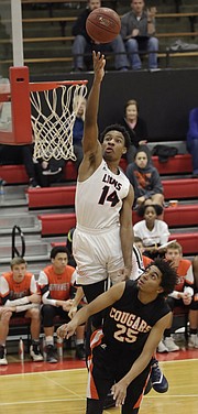Lawrence High junior Anthony Selden (14) is fouled on a dunk attempt in a 6A sub-state win against Shawnee Mission Northwest, March 1, at LHS.