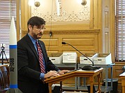 University of Kansas professor Ron Barrett-Gonzalez stands with a model of a drone missile being developed at KU, telling a legislative committee that it's one example of a research project soon to leave Kansas because of the state's expansive laws allowing people to carry concealed handguns on college campuses.