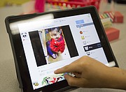 A Sunset Hill kindergartner watches a correspondence video of a Shanghai kindergartner playing a xylophone.