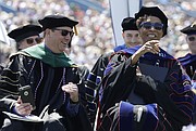 Douglas A. Girod, M.D., executive vice chancellor of the University of Kansas Medical Center, left, and KU Chancellor Bernadette Gray-Little react to chants from the graduates asking Gray-Little to stay one more year. Gray-Little has announced she is stepping down this summer. The two participated in the KU commencement ceremonies Sunday, May 14, 2017 on the KU campus.