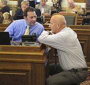 Kansas state Reps. Troy Waymaster, left, R-Bunker Hill, and Russ Jennings, R-Lakin, confer before the House's debate on overriding Republican Gov. Sam Brownback's veto of a bill increasing income taxes to fix the state budget, Tuesday, June 6, 2017, in Topeka, Kan. Both Jennings and Waymaster, the House Appropriations Committee chairman, voted to override. (AP Photo/John Hanna)