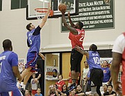 Jeff Withey, left, jumps to block a shot by Mario Little during the 2017 Rock Chalk Roundball Classic Thursday evening at Lawrence Free State High School. The annual charity event benefits local families fighting cancer