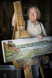Lawrence resident Peter Johnson is pictured with one of his paintings of the Kansas River on Thursday, June 22, 2017, at his studio in North Lawrence. Johnson, who is a painter, printmaker, and who also enjoys drawing, will be showing his work at the Summer Fest arts fair on June 25 at South Park.