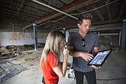 Allison McEldowney, a marketing creative director, and Zach Lee, a designer hired by the owners of McLain's Market in Overland Park, look through a tablet with design plans within the former Jayhawk Bookstore location, 1420 Crescent Road on Monday, Aug. 14, 2017.