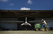 Vinland Valley Aerodrome groundskeeper Ken Kern drives his mower past a plane on Tuesday, Aug. 29, 2017 at the Vinland Airport.