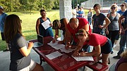Area residents gather and sign petitions Saturday at Chieftain Park in Tonganoxie during an informational meeting for Citizens Against Project Sunset, a group that opposes the proposed Tyson chicken facility.