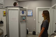 Journal-World health reporter Mackenzie Clark, left, is shown inside the cryosauna at Optimal Wellness and Cryospa as general manager Tashina Case stands by.