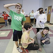 Playing a Native American game called Sweep the Teepee, Southwest Middle School eighth-graders David Wiseman, standing left and Naomi Wakhungu, standing right, form with other students to create a “look over horse” group to stay in the game. Haskell Indian Nations University and SWMS students participated in Share Southwest activities at at the school Wednesday, Nov. 15. The event was a collaboration between Haskell students and the SWMS Native Club.