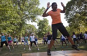 In this file photo from July 2012, Susan King, a fitness instructor with Lawrence Parks and Recreation, leads a group in a Zumba in the Park event amid triple-digit temperatures.