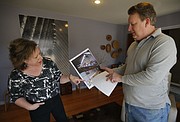 In this AP File photo from March 29, 2013, Adlynn and Robert Harte share photos from the day of a police raid on their home in Leawood.