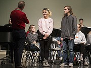 Free State High School students Harlee Crossett, center, and Gabriel Leverette, listen as Mike Meyer of Meyer Music notifies them that they are the recipients of new instruments through Meyer Music's Band of Angels program, Thursday, Dec. 7, 2017 in the auditorium at Free State High School.
