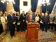 Sen. Tom Holland, center, D-Baldwin City, announces some of the government transparency initiatives he is sponsoring in the 2018 session during a news conference Tuesday with the House and Senate Democratic caucuses.