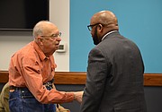 Austin Turney, a former Lawrence school board member, shakes hands with Anthony Lewis, the newly approved district superintendent, at the board meeting Monday, Jan. 29, 2018 at district offices, 110 McDonald Drive.
