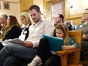 Joe Sessel of Topeka takes notes while also tending to his daughter Claire during a committee hearing Tuesday on a bill that would put more pressure on courts to order shared custody and parenting in divorce cases.