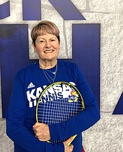 Ann Anderson, coach of the senior tennis class at the Jayhawk Tennis Center, poses with her racket on Feb. 2, 2018, at JTC, 233 Rock Chalk Lane. She has been playing tennis since she was 4 years old.