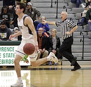 High school basketball official Phil Lombardi trails the play while keeping a 10-second count during Saturday's game between Free State and Bishop Miege at FSHS.