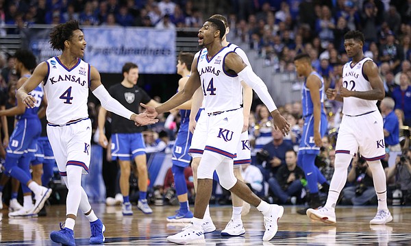 Kansas guard Devonte' Graham (4) and Kansas guard Malik Newman (14) celebrate a three in overtime by Newman, Sunday, March 25, 2018 at CenturyLink Center in Omaha, Neb.