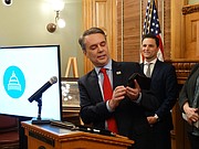 During a March 29, 2018, news conference, Gov. Jeff Colyer demonstrates a new mobile app called "iKan" that allows users to renew their vehicle registrations online. State officials said they also plan to expand uses of the app to provide access to other services like accessing birth certificates and registering to vote.