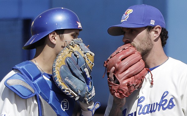 Kansas catcher Jaxx Groshans, left, visits with starting pitcher Taylor Turski in the early innings of the Jayhawks' home game against Texas Tech, Saturday, April 7, 2018, at Hoglund Ballpark. KU fell to Texas Tech, 10-0.