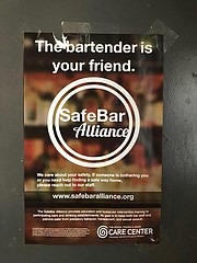 A SafeBar Alliance sign, located in the Burger Stand restroom, encourages staff and patrons to seek help if they are made uncomfortable in the restaurant.