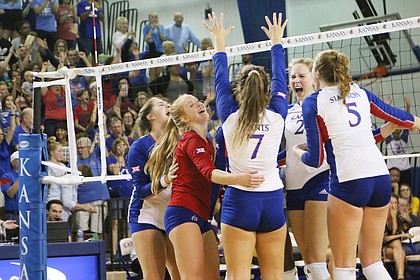 Kansas celebrates a match win after against West Virginia Wednesday night. The Jayhawks rallied back down two sets to earn a 3-2 win over the Mountaineers.