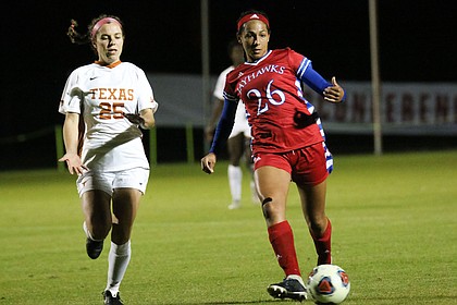 Defender Addisyn Merrick chases a ball past Texas' Katie Glenn at the Big 12 Soccer Championships in Swope Soccer Village on Sunday, October 28.