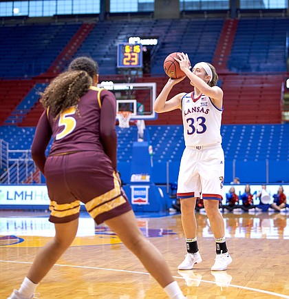 Kansas guard Kylee Kopatich (33) shoots a 3-pointer as Iona's Shyan Mwai (5) looks on in the first quarter on Sunday, Nov. 25, 2018 at Allen Fieldhouse.